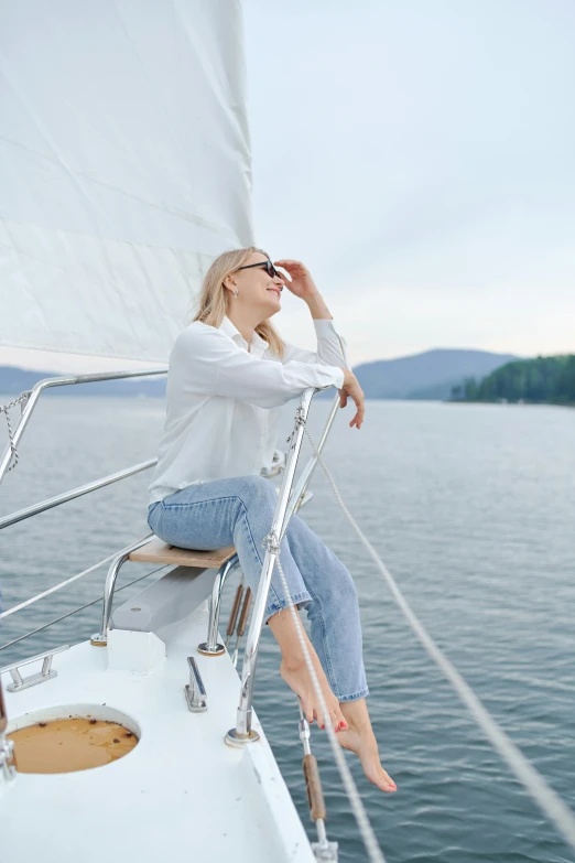 a woman sitting on the bow of a sailboat, wearing a white button up shirt, new hampshire, floating in air, clean and pristine design