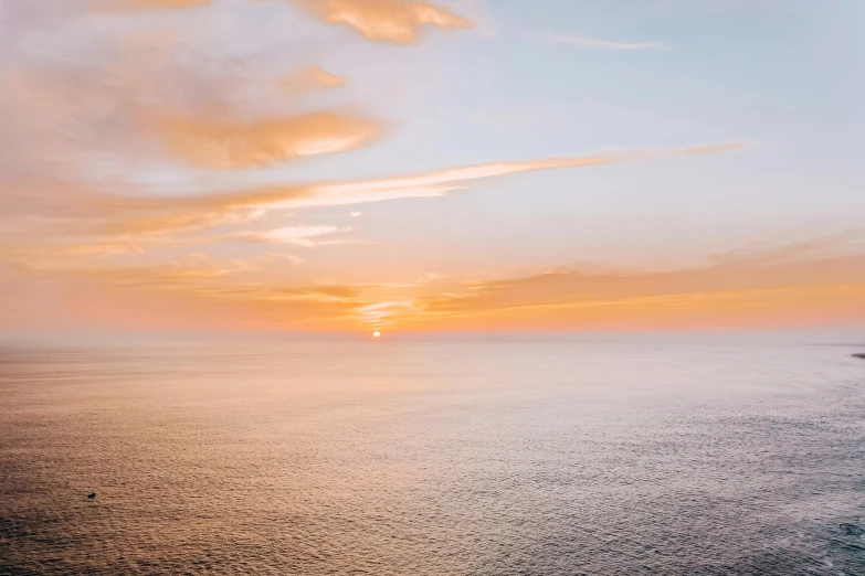 a large body of water with a sunset in the background, pexels contest winner, views to the ocean, birdseye view, pastel orange sunset, desktop wallpaper