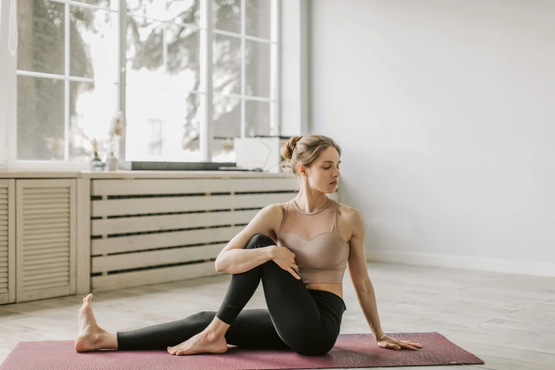 a woman sitting on a yoga mat in front of a window, trending on pexels, arabesque, aussie, brunette fairy woman stretching, as well as scratches, thumbnail