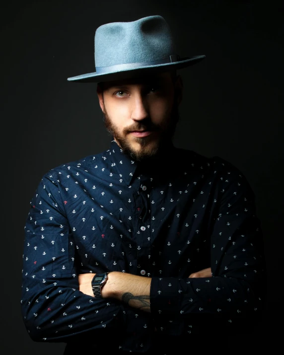 a man wearing a hat with his arms crossed, an album cover, inspired by Germán Londoño, trending on unsplash, lgbtq, headshot profile picture, dapper, journalist photo