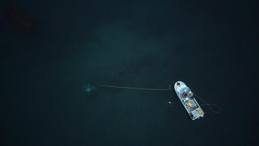 a boat floating on top of a body of water, by Sebastian Spreng, pexels contest winner, hurufiyya, dredged seabed, floating power cables, aerial view cinestill 800t 18mm, floating kelp