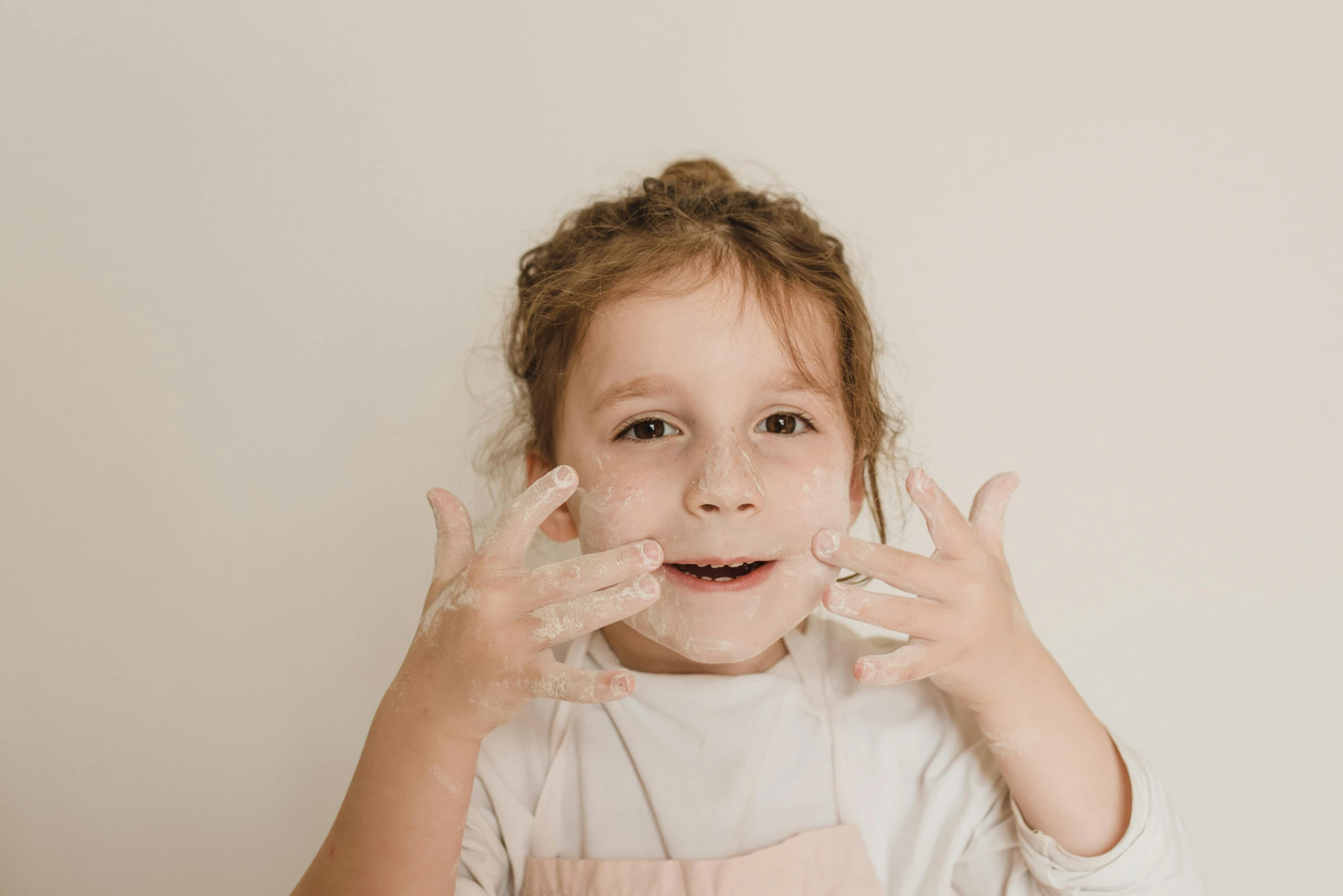 a little girl making a funny face with her hands, a stipple, pexels contest winner, photoshoot for skincare brand, messy eater, transparent face, petite