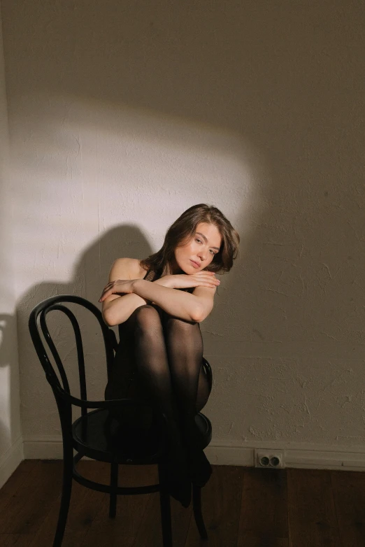 a woman sitting on a chair in a room, an album cover, inspired by Anna Füssli, pexels contest winner, girl with brown hair, non binary model, satisfied pose, sofia coppola