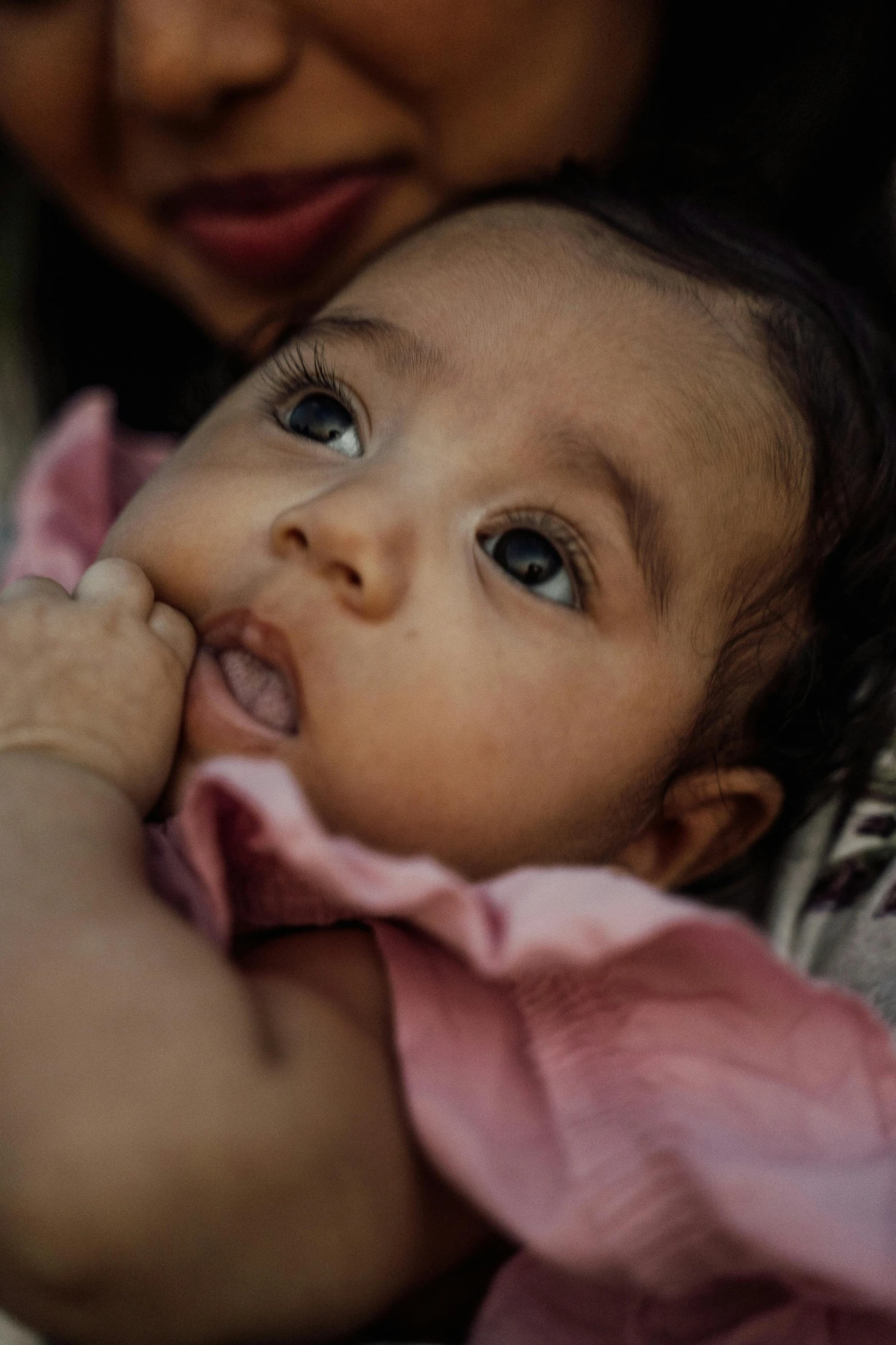 a woman holding a baby in her arms, pexels contest winner, hand on her chin, indian girl with brown skin, closeup of an adorable, pink face