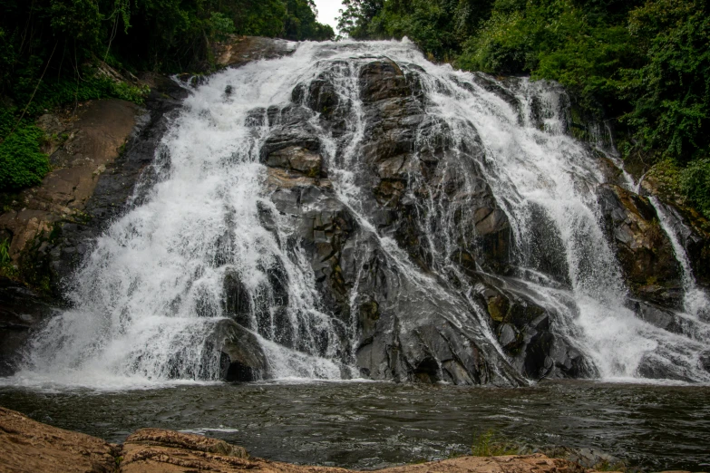 a large waterfall in the middle of a forest, hurufiyya, fan favorite, shot with sony alpha 1 camera, low - angle shot, 2 0 0 0's photo