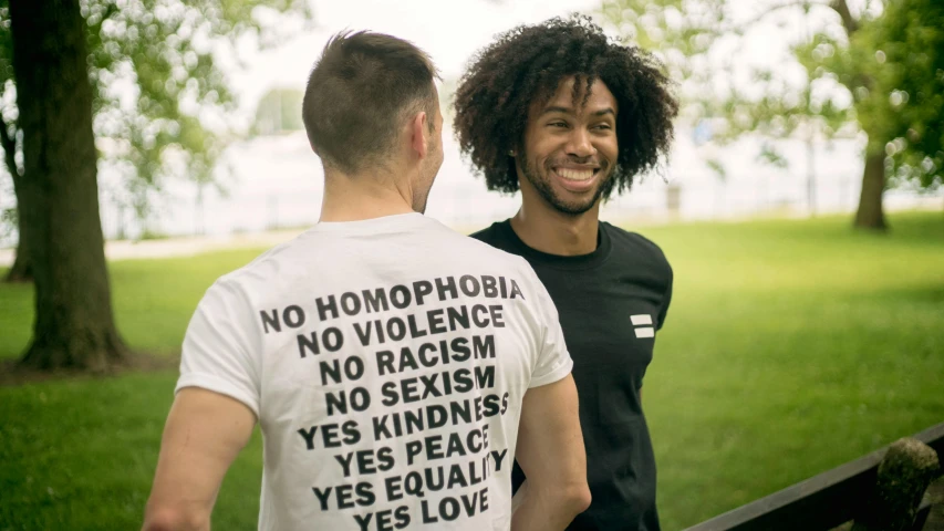 a couple of men standing next to each other, unsplash, gay rights, wearing a tee shirt and combats, a person standing in front of a, yes
