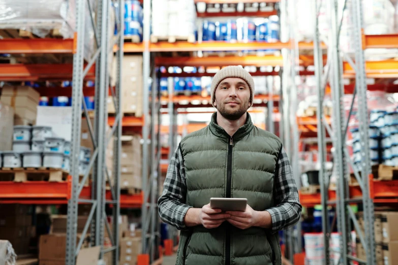 a man standing in a warehouse holding a tablet, a portrait, shutterstock, worksafe. instagram photo, thumbnail, curious, full pallet image