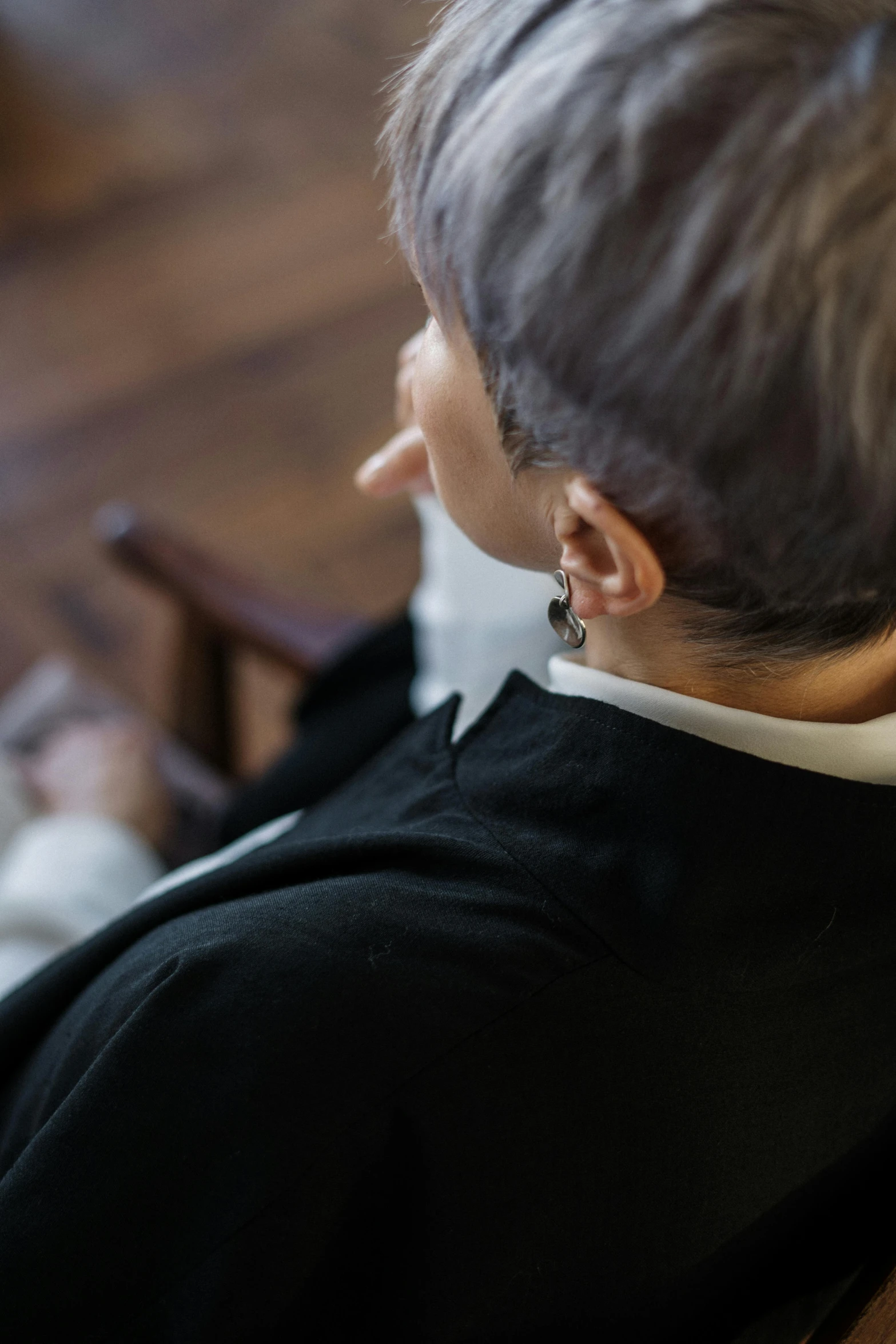 a woman sitting in a chair using a laptop computer, by Jan Pynas, trending on unsplash, short silver grey hair, wearing dark silk robe, profile image, collar on neck