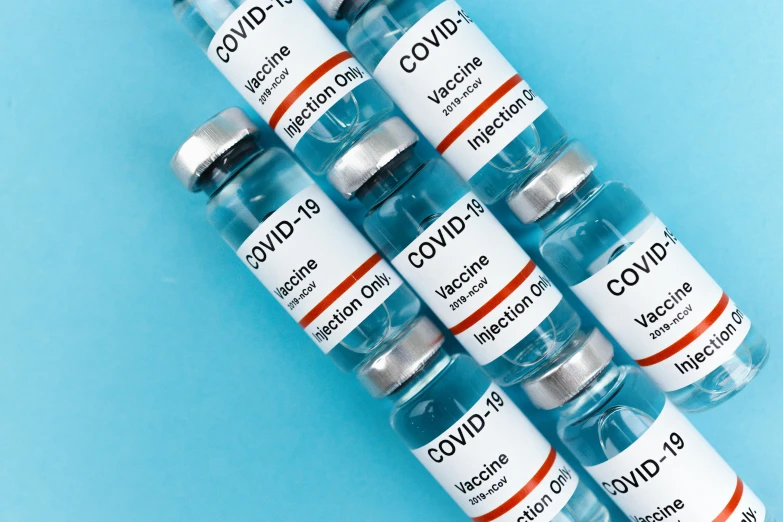 a bunch of vials sitting on top of a blue surface, covid, label, gray, thumbnail