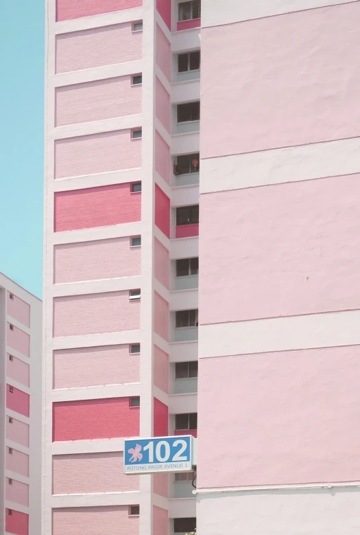a pink building with a street sign in front of it, unsplash contest winner, postminimalism, singapore ( 2 0 1 8 ), high rises, pastels, stacked image