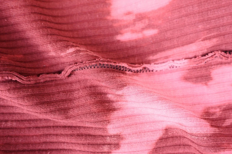 a close up of a piece of fabric on a table, pink body, split dye, a pair of ribbed, wear and tear