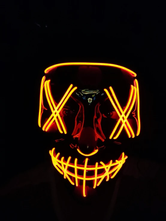 a person wearing a neon mask in the dark, pexels contest winner, shock art, orange and yellow costume, smirking, spooky filter, neon!! light