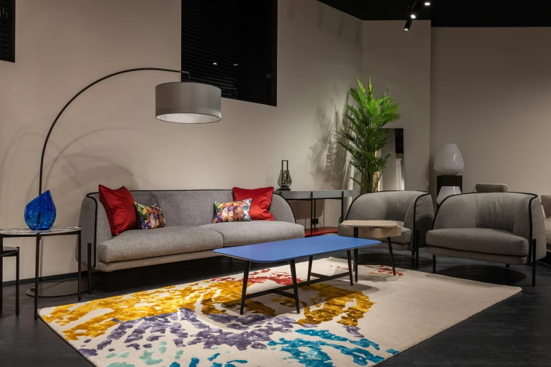 a living room filled with furniture and a lamp, inspired by Emilio Grau Sala, unsplash, conceptual art, rugs, black and yellow and red scheme, maroon and blue accents, in a gallery setting