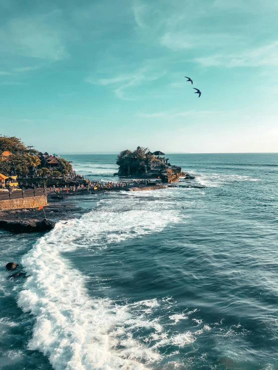 a large body of water next to a beach, pexels contest winner, happening, the village on the cliff, waving, flying rocky island, bali