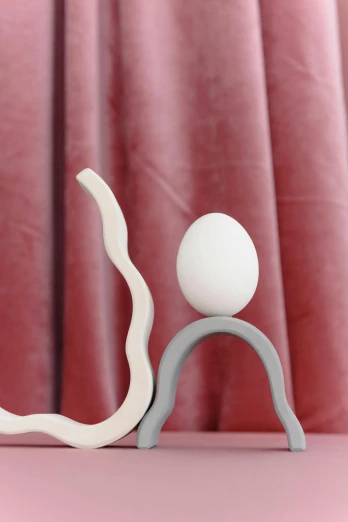 a couple of figurines sitting on top of a table, an abstract sculpture, inspired by Jean Arp, trending on reddit, eggs, detail shot, wavy, long arm