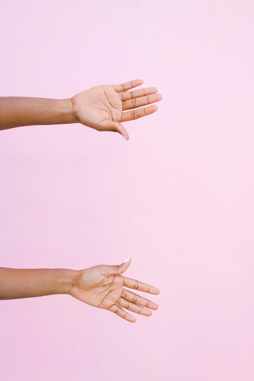 two hands reaching towards each other on a pink background, by Carey Morris, trending on pexels, symmetrical pose, any racial background, instagram post, empty background