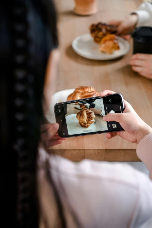 a woman taking a picture of a plate of food, holding toasted brioche bun, leica s photograph, in a coffee shop, made of glazed