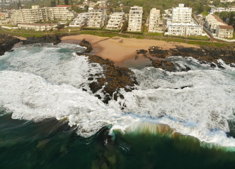 a large body of water next to a beach, by Simon Marmion, pexels contest winner, south african coast, apartment, airborne view, 4k footage