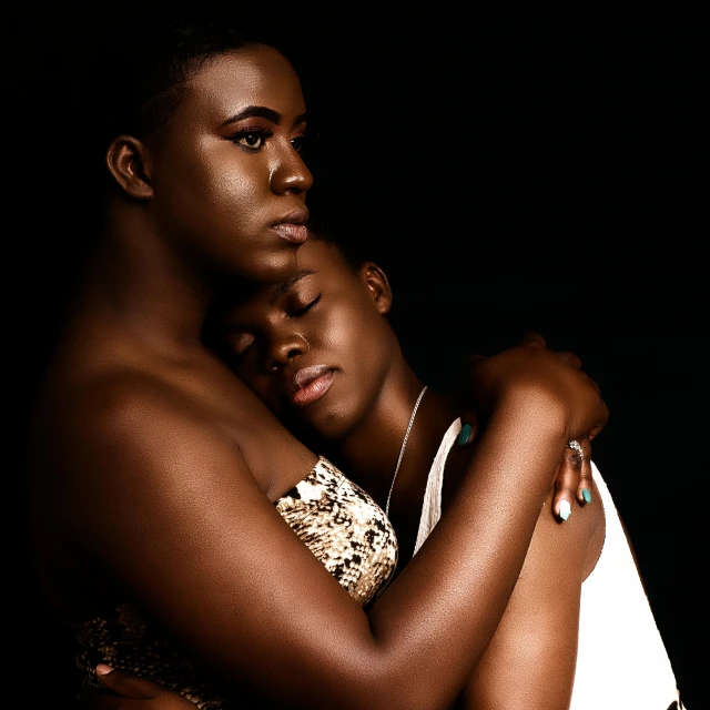 a man and a woman hugging in front of a black background, by Lily Delissa Joseph, two young men, modeled, pride, slide show