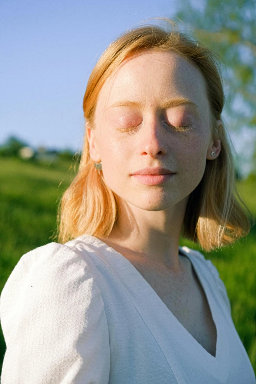 a woman standing in a field with her eyes closed, pale glowing skin, portrait of sanna marin, on a sunny day, 2019 trending photo