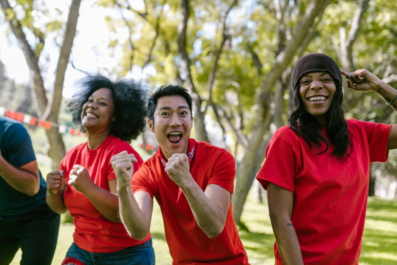 a group of people in red shirts standing next to each other, pexels contest winner, happening, smiling playfully, sydney park, avatar image, cheering