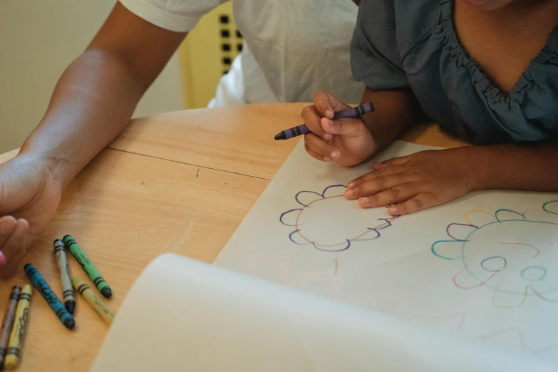 a couple of people sitting at a table with crayons, a child's drawing, by Arabella Rankin, pexels contest winner, whiteboards, subtle details, teacher, a high angle shot