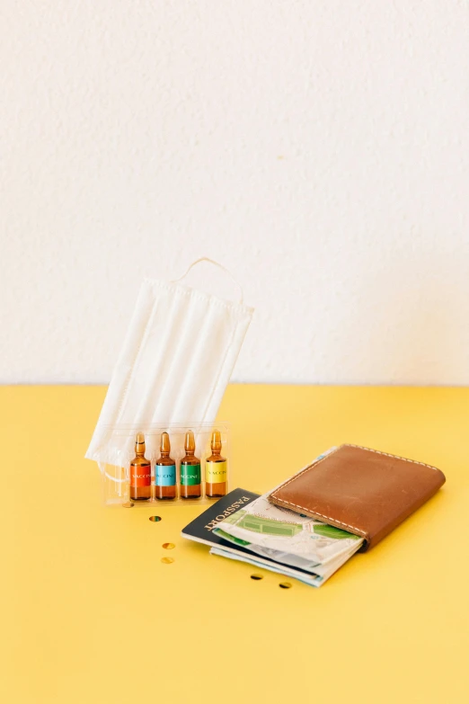 a wallet sitting on top of a yellow table, vibrant vials, collection product, serene environment, medium-shot