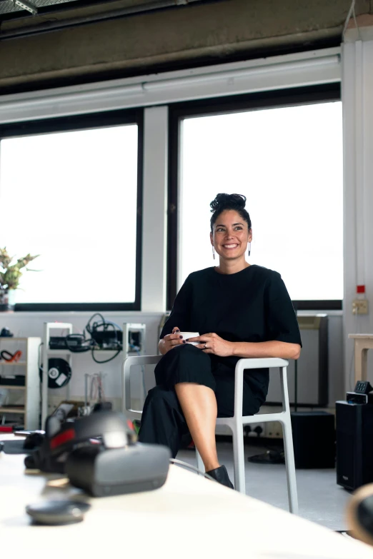 a woman sitting on a chair in a room, the designer's republic, profile image, aida muluneh, in office