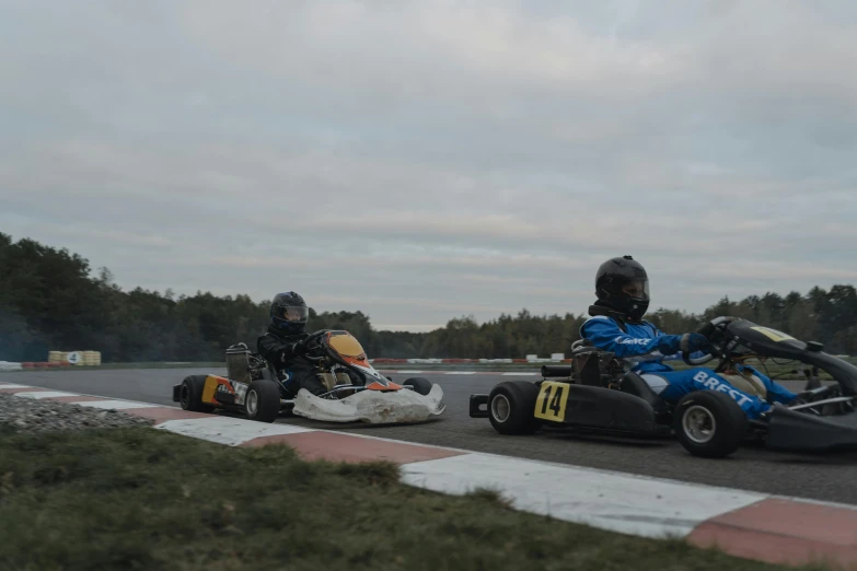 a couple of people riding karts on top of a race track, by Jaakko Mattila, square, low quality photo, fall season, profile picture