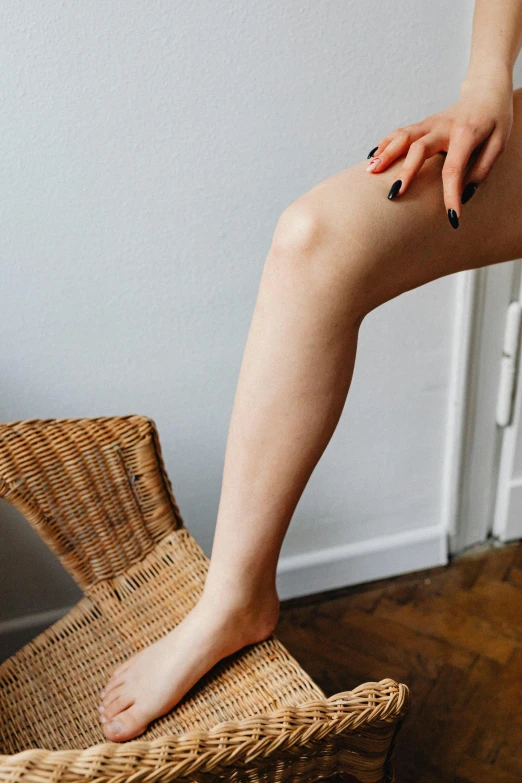 a woman sitting on top of a wicker chair, by Niko Henrichon, trending on pexels, renaissance, thigh skin, vastus lateralis, at home, close up to a skinny