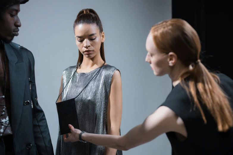a group of people standing next to each other, a hologram, by Nina Hamnett, pexels contest winner, hyperrealism, holding a leather purse, performance art, two models in the frame, inspect in inventory image