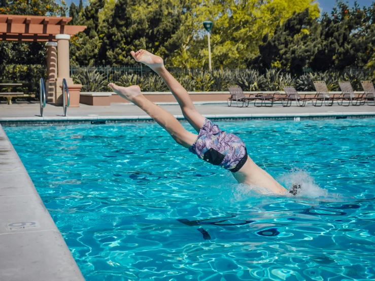 a person diving into a swimming pool, posing, blog-photo, photo taken with sony a7r camera, high kick