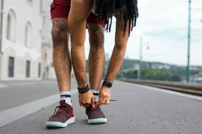 a man with dreadlocks tying his shoe, pexels contest winner, train with maroon, avatar image, athletic shorts, walkable