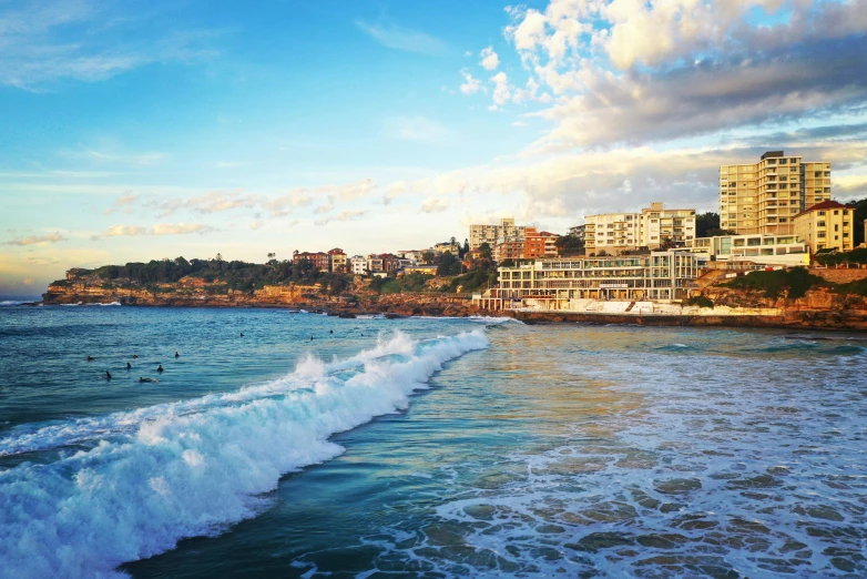 a large body of water next to a beach, pexels contest winner, bondi beach in the background, lebanon kirsten dunst, warm light, slide show