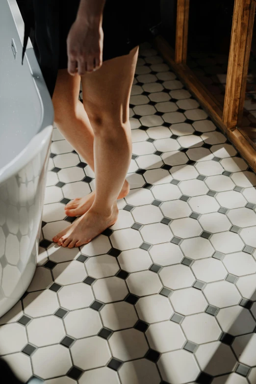 a woman standing next to a bath tub in a bathroom, pexels contest winner, floor tiles, legs intertwined, gaming toilet, profile image
