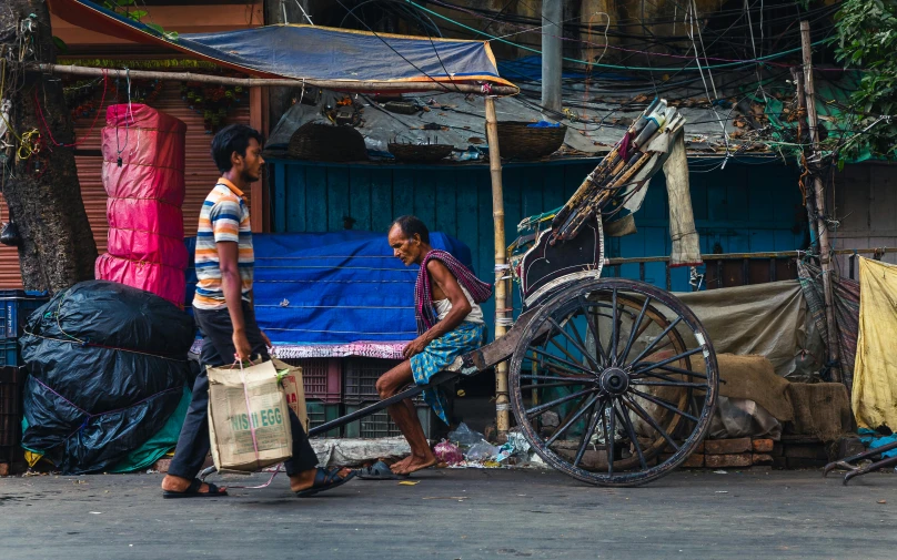 a couple of men walking down a street next to a cart, pexels contest winner, bengal school of art, thumbnail, market setting, sprawling, proportional image