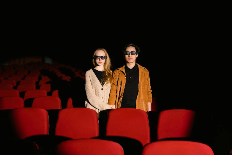 a man and a woman standing next to each other in a theater, inspired by Nan Goldin, pexels, hyperrealism, wearing 3 d glasses, sitting, film key art, instagram picture