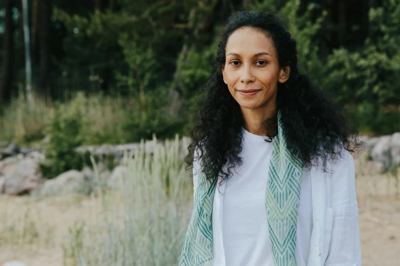 a woman in a white shirt and green tie, a portrait, by Helen Stevenson, featured on unsplash, hurufiyya, standing in a botanical garden, white scarf, sea - green and white clothes, zoe saldana