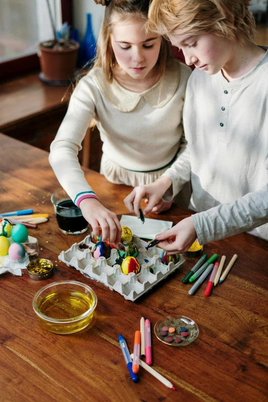 a couple of kids that are sitting at a table, pexels, process art, easter, on a wooden tray, square, maintenance