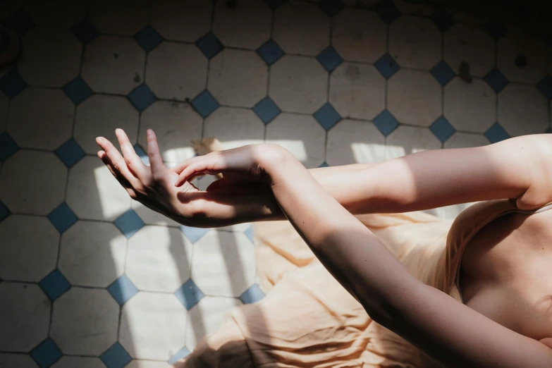 a woman laying on top of a bed next to a window, inspired by Elsa Bleda, trending on pexels, light and space, partially cupping her hands, casting a protection spell, woman holding another woman, on a checkered floor