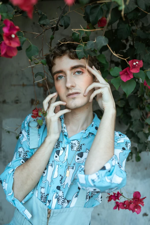 a man in a blue shirt talking on a cell phone, an album cover, by Jessie Alexandra Dick, trending on pexels, aestheticism, blue-eyed man, covered in flowers, an epic non - binary model, douglas smith