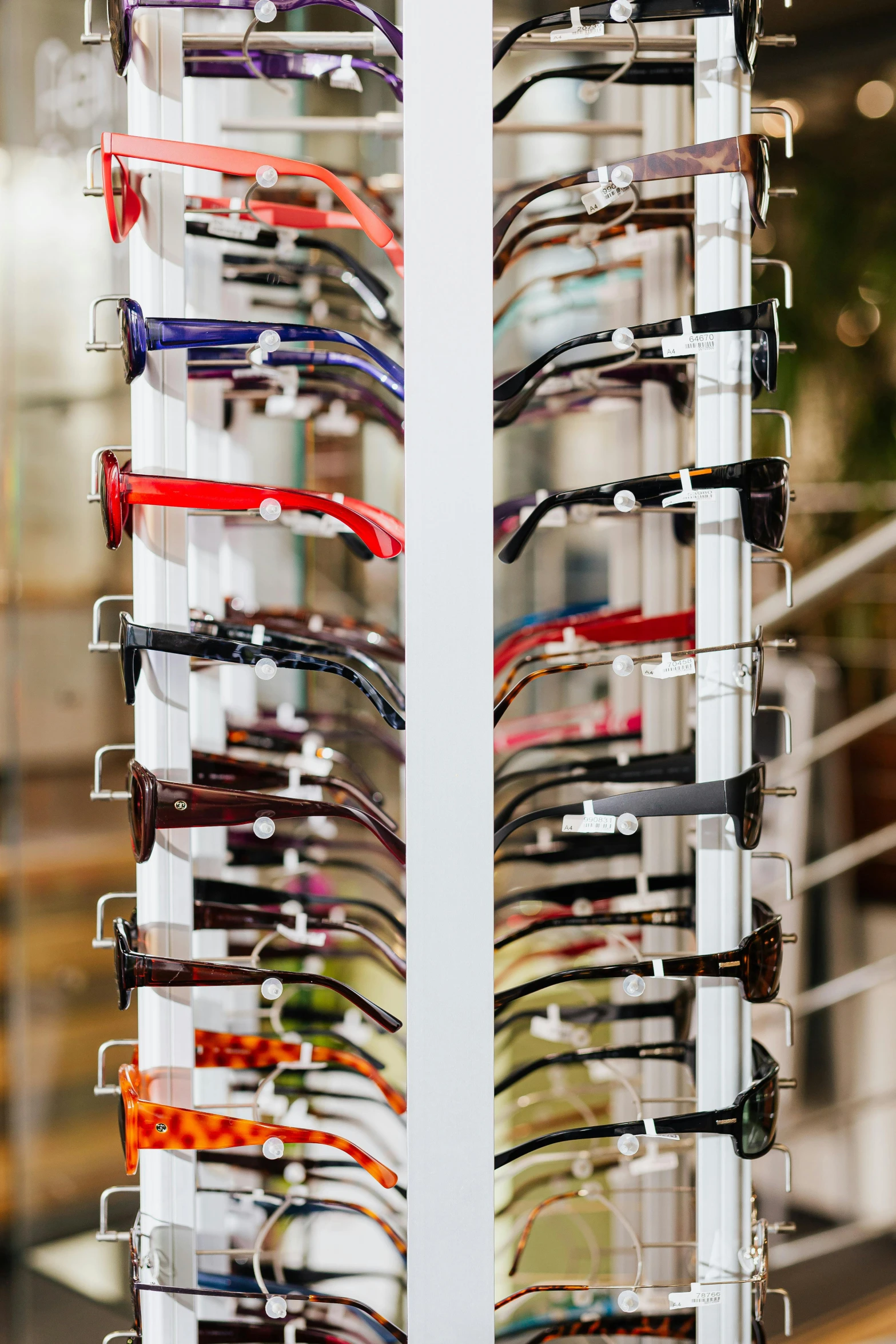 a rack with many pairs of glasses on it, official store photo, many eyes, square glasses, center of image