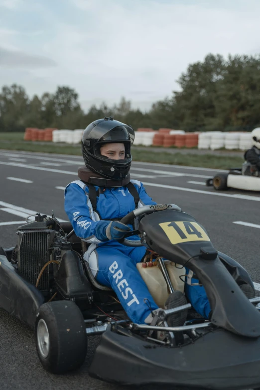 a man driving a go kart on a race track, by Cornelisz Hendriksz Vroom, reddit, square, portrait mode photo, woman, battle ready