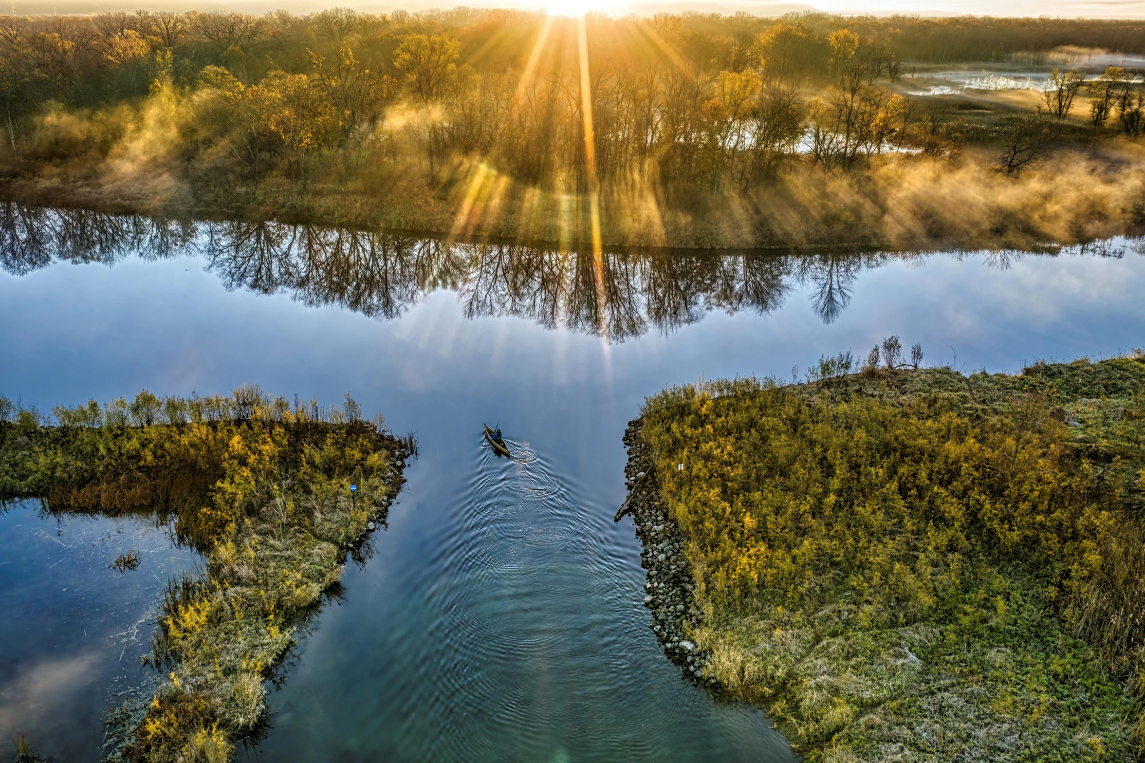 a large body of water surrounded by trees, a picture, by Jan Tengnagel, pexels contest winner, land art, sun lighting from above, morning sun, great river, guide