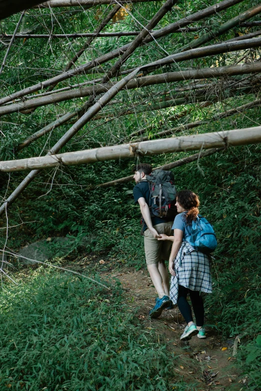 a couple of people that are walking in the woods, unsplash, renaissance, laos, fallen trees, trecking, made of bamboo