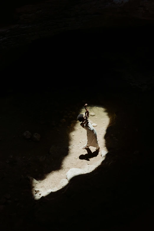 a baseball player holding a bat on top of a field, an album cover, by Alexis Grimou, unsplash contest winner, in a large desert cave, shadowy figures, photograph from above, she is walking on a river