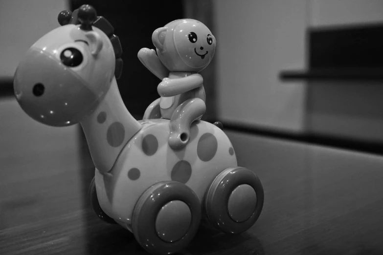 a toy giraffe sitting on top of a wooden table, a black and white photo, toyism, driving in a little toy car, ((robot)), riding a hippo, monochrome hdr