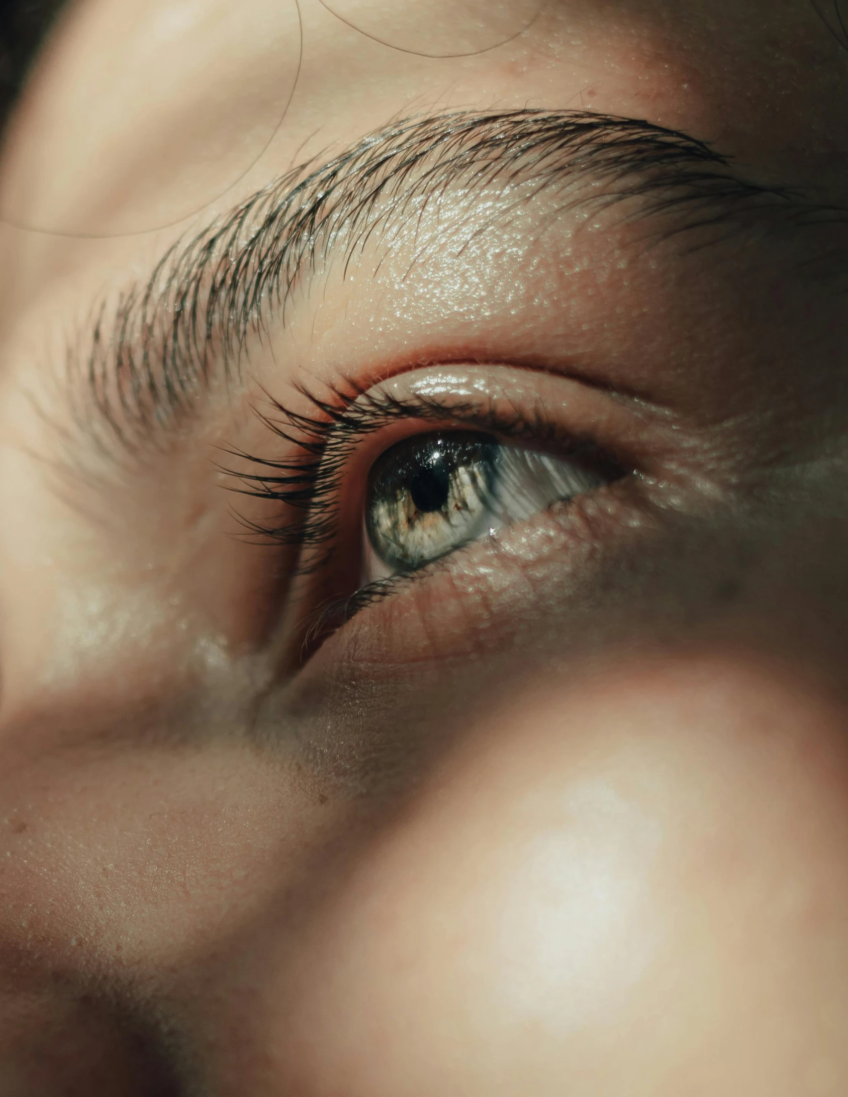 a close up of a person's eye with long eyelashes, by Adam Marczyński, trending on pexels, hyperrealism, iridescent skin, androgynous face, wrinkles and muscle tissues, looking across the shoulder