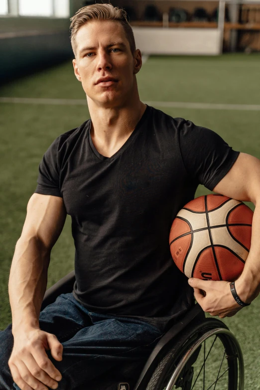 a man in a wheelchair holding a basketball, by Adam Marczyński, tight black tank top and shorts, portrait of tom holland, 15081959 21121991 01012000 4k, attractive sporty physique