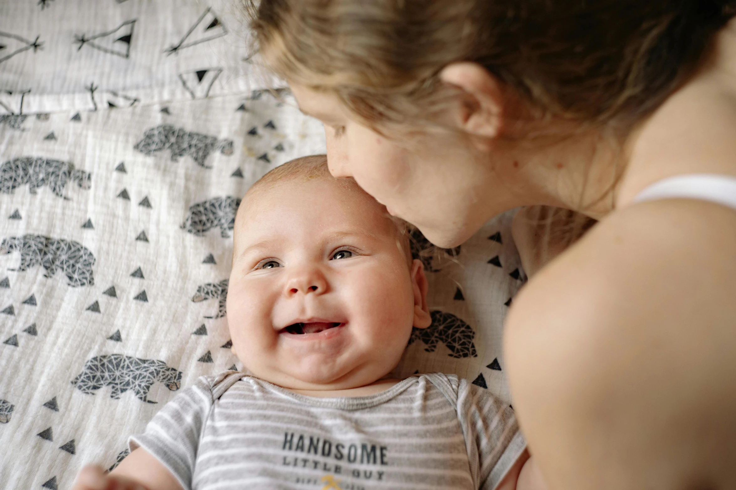 a woman holding a baby on top of a bed, pexels contest winner, happening, happy with his mouth open, smug smile, avatar image, high angle close up shot